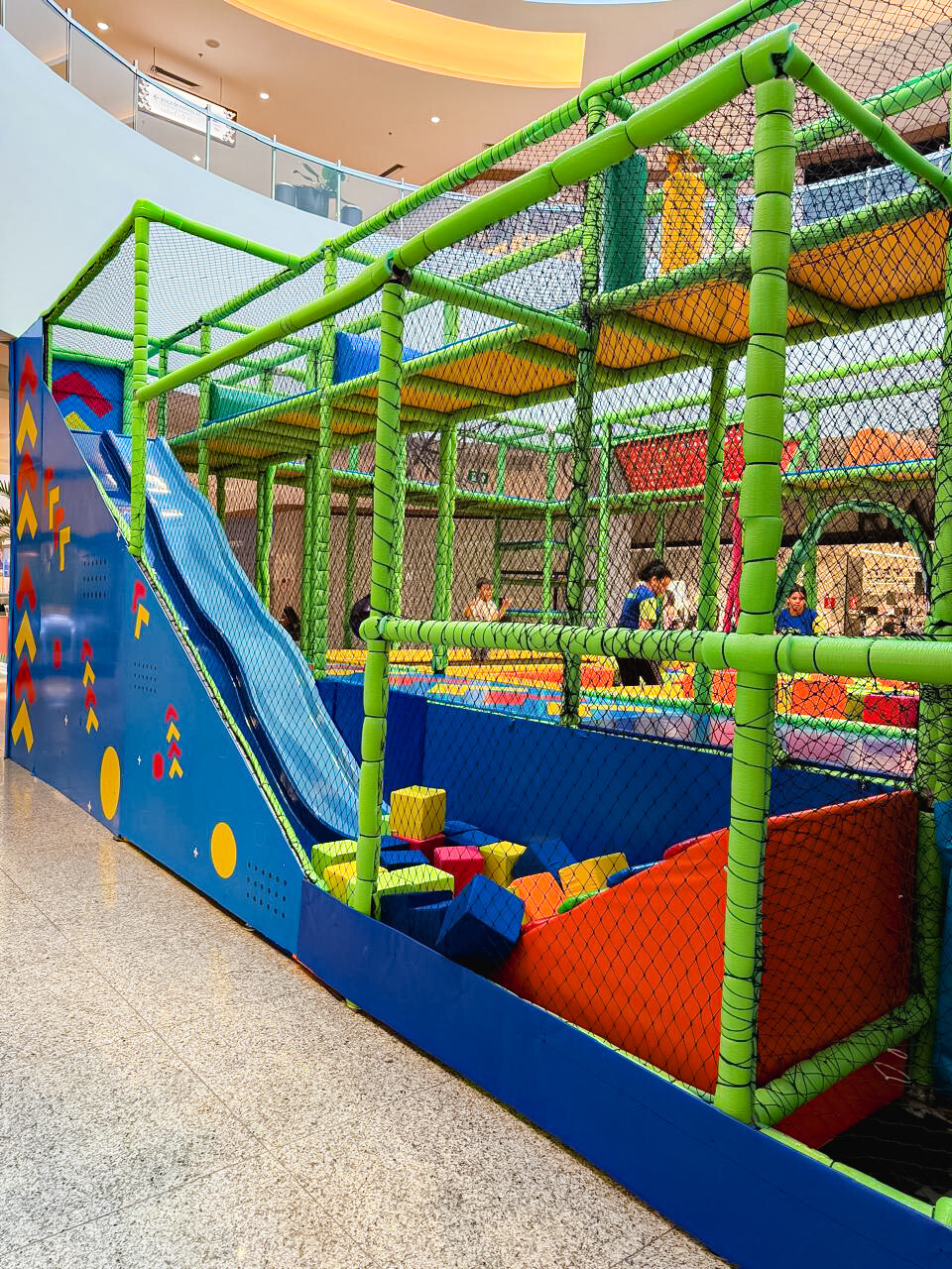 1 Estrutura do Zoe Park com escorregador e piscina de bolinhas montada no corredor de um shopping